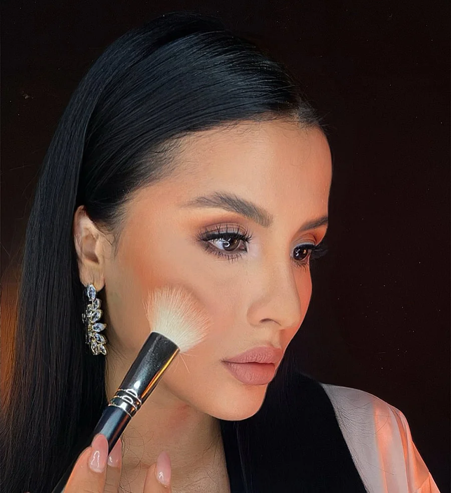 aplicación de maquillaje profesional con brocha en el rostro