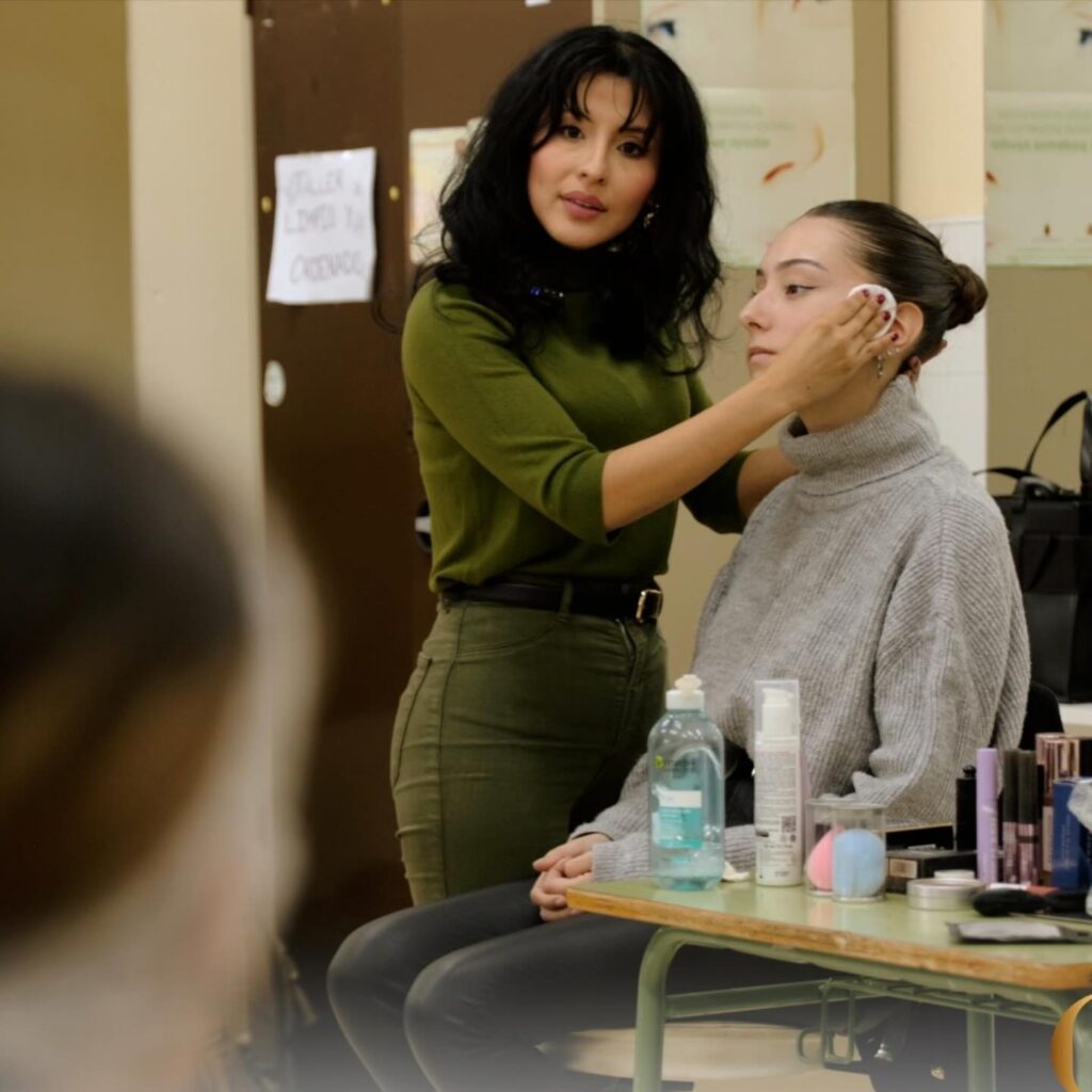 Maquilladora profesional enseñando técnica de preparación de piel en clase presencial de maquillaje