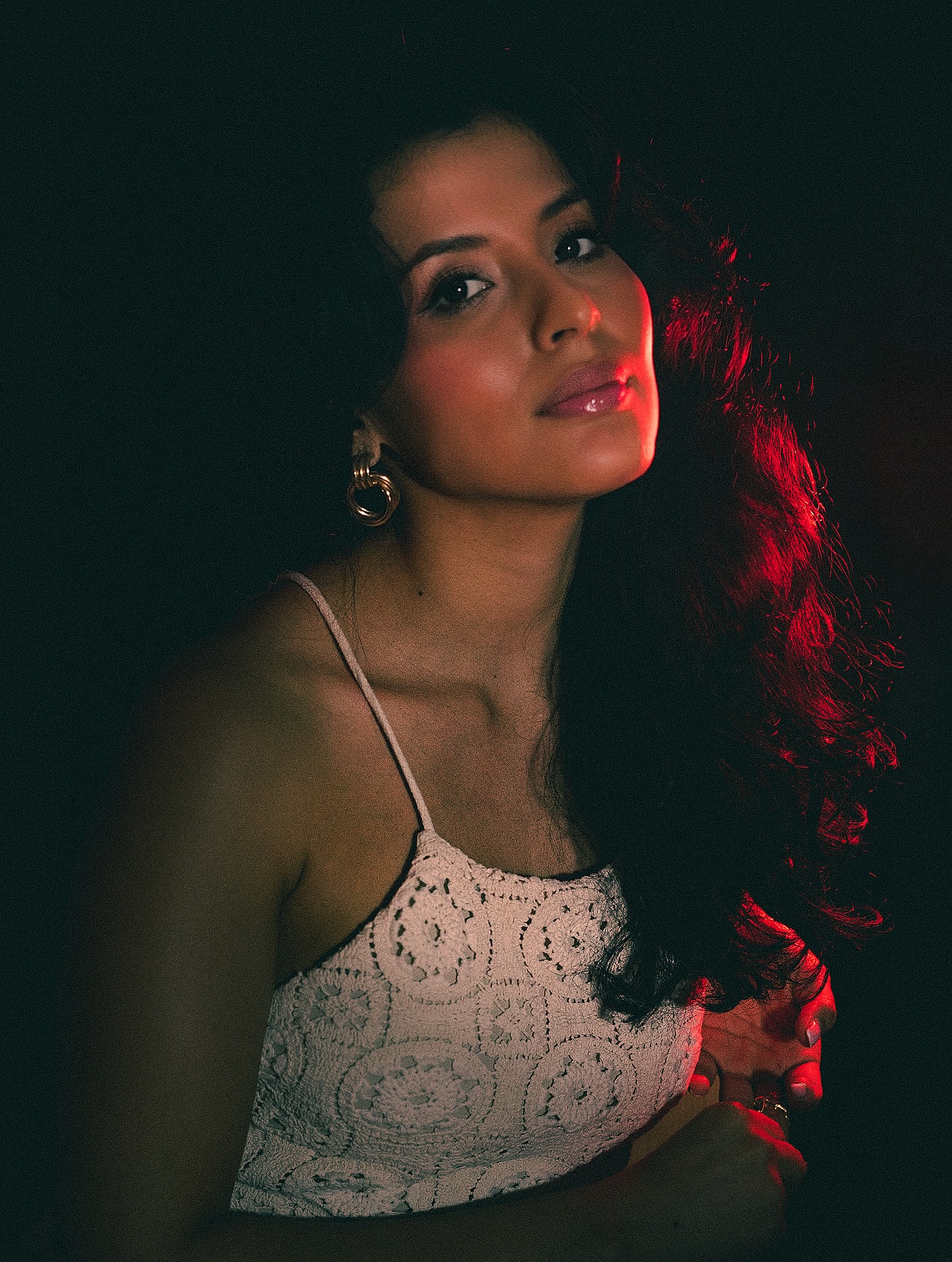 Retrato femenino con maquillaje profesional y luz roja artística