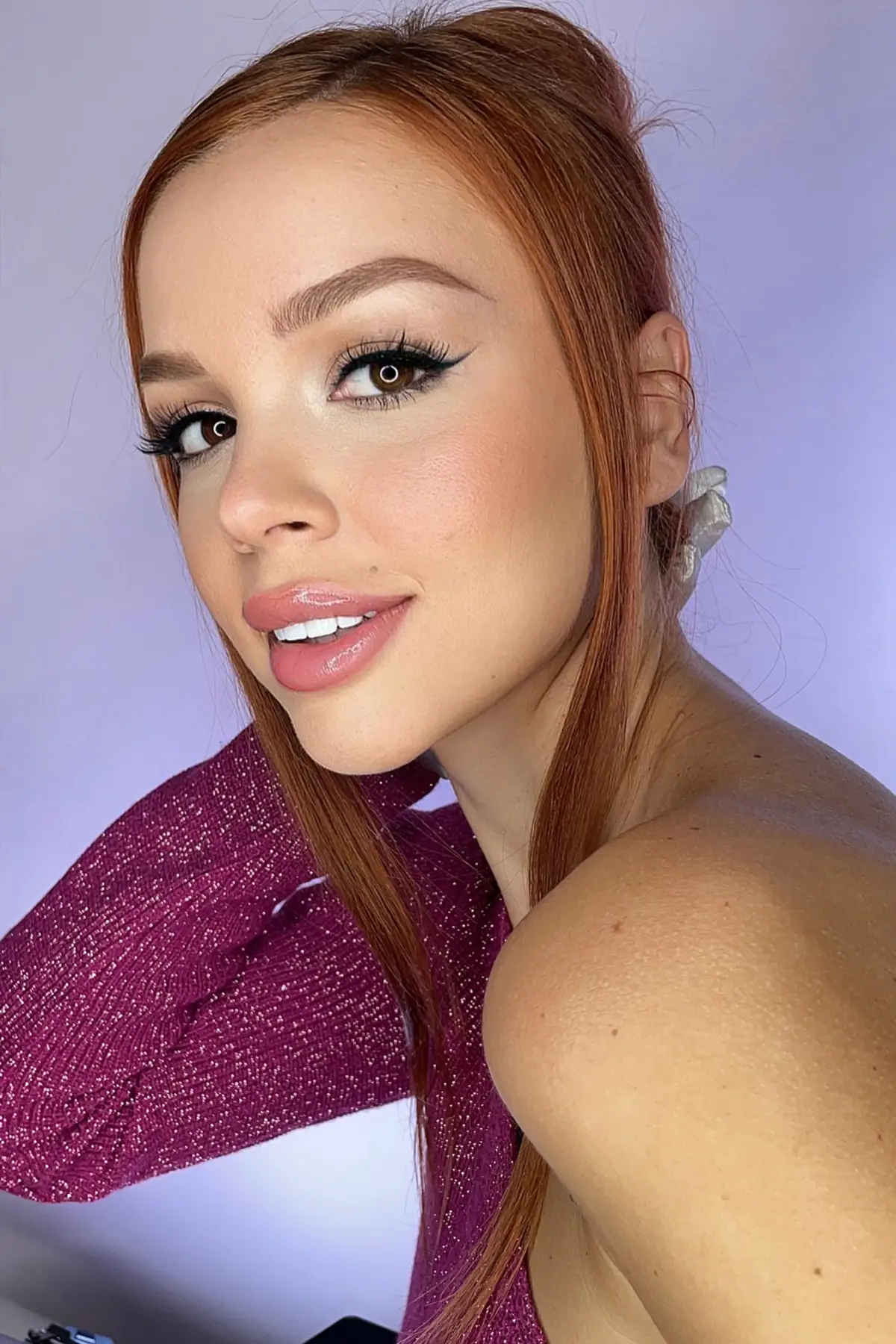 Modelo pelirroja con piel uniforme y maquillaje profesional de acabado natural