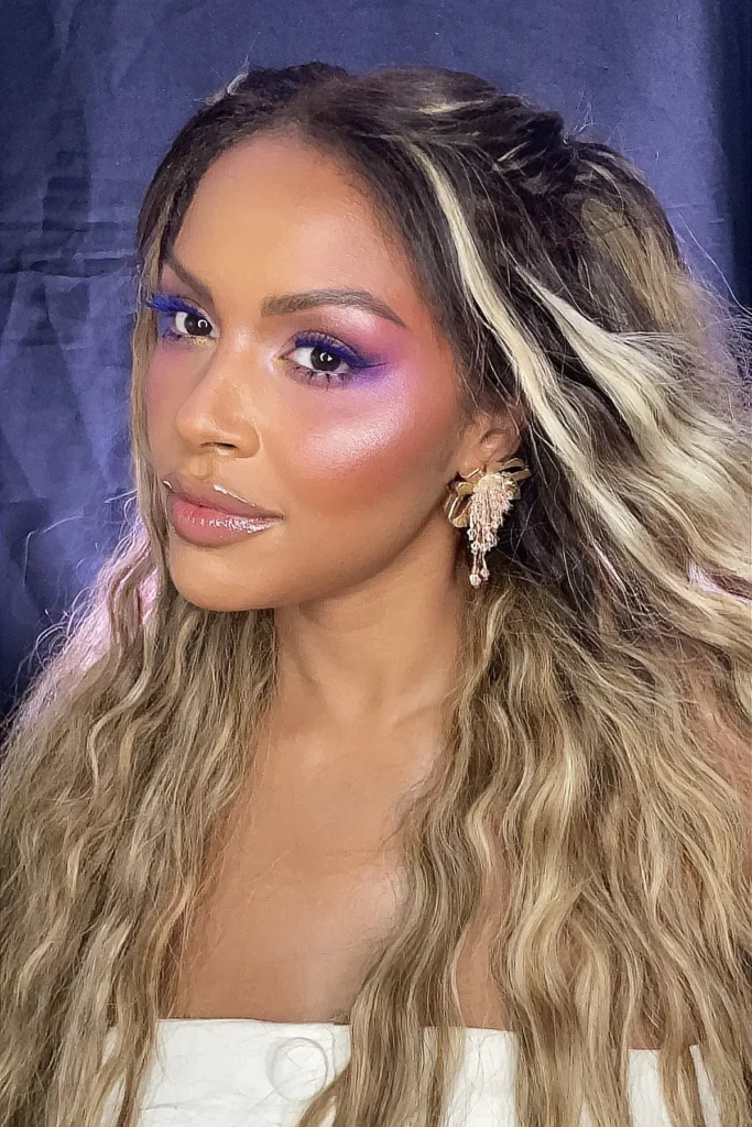 Mujer con maquillaje profesional de ojos en tonos rosa y violeta y acabado luminoso