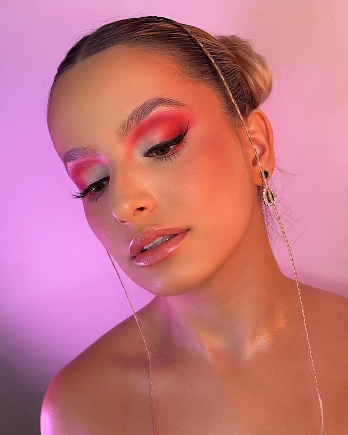 Maquillaje de ojos en tonos rojos y rosados con delineado negro difuminado