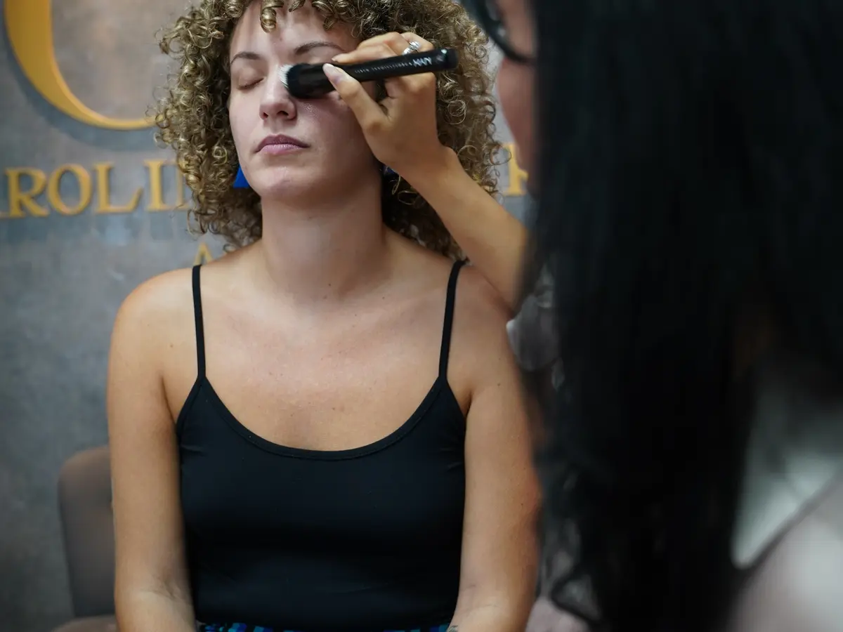 Uso higiénico de brochas de maquillaje profesional Maquilladora aplicando producto con una brocha en el rostro de una clienta